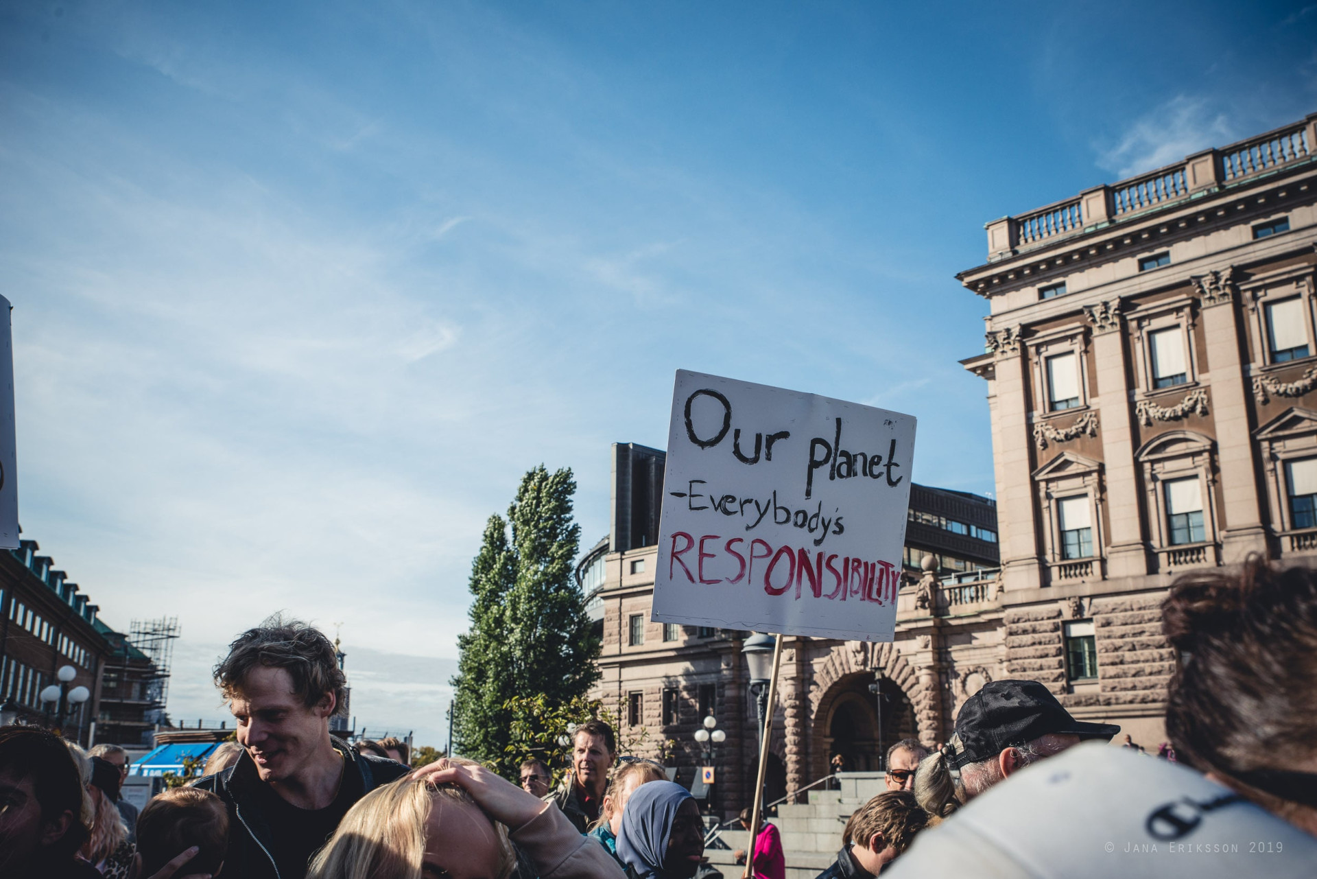 Aktivister går i ett demonstrationståg utanför Sveriges riksdag.